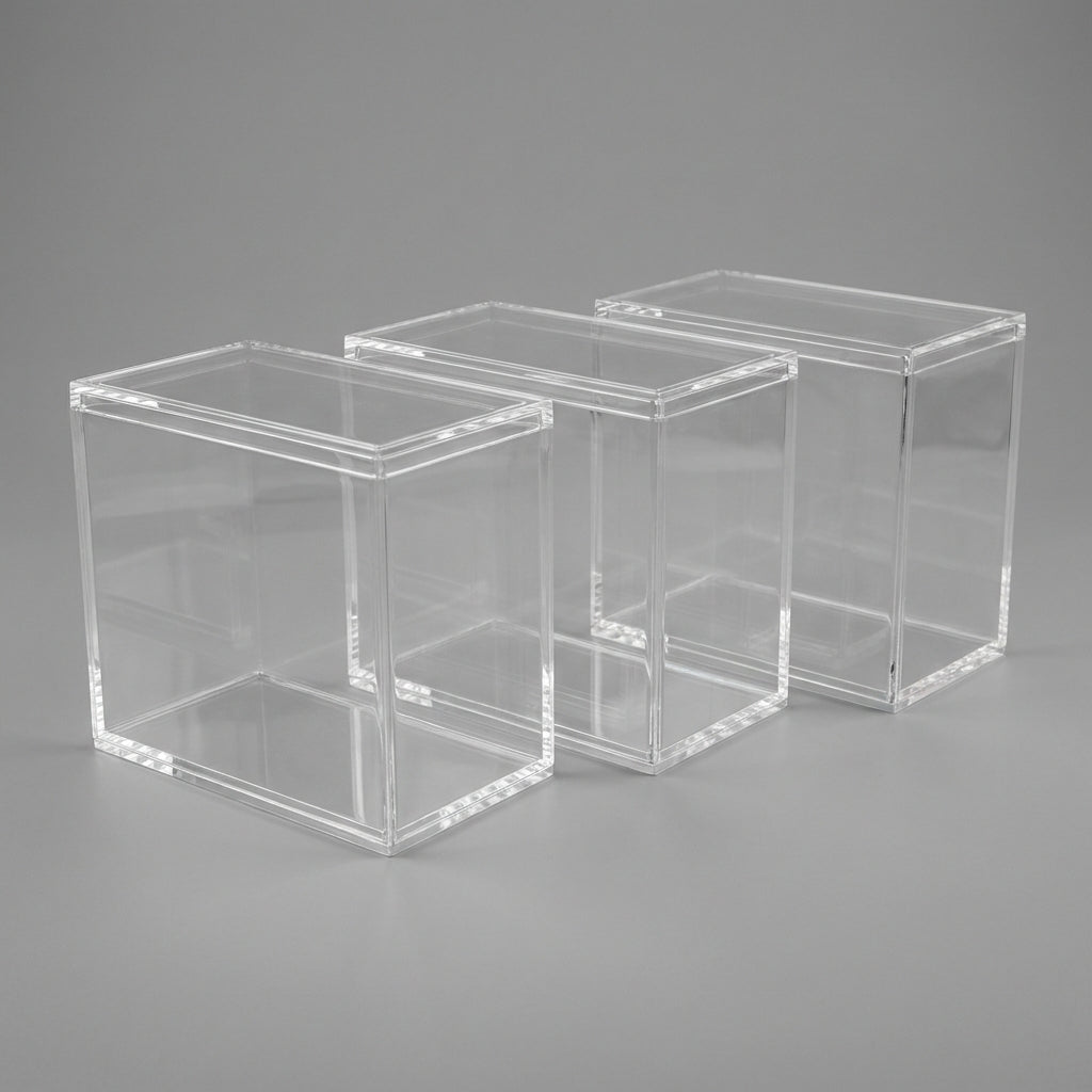 Three empty acrylic Elite Trainer Box display cases with lids on a neutral background
